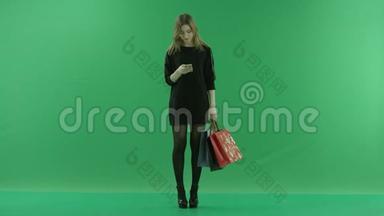 年轻女子带着袋子在智能手机上<strong>上网</strong>，彩色钥匙<strong>绿色</strong>背景